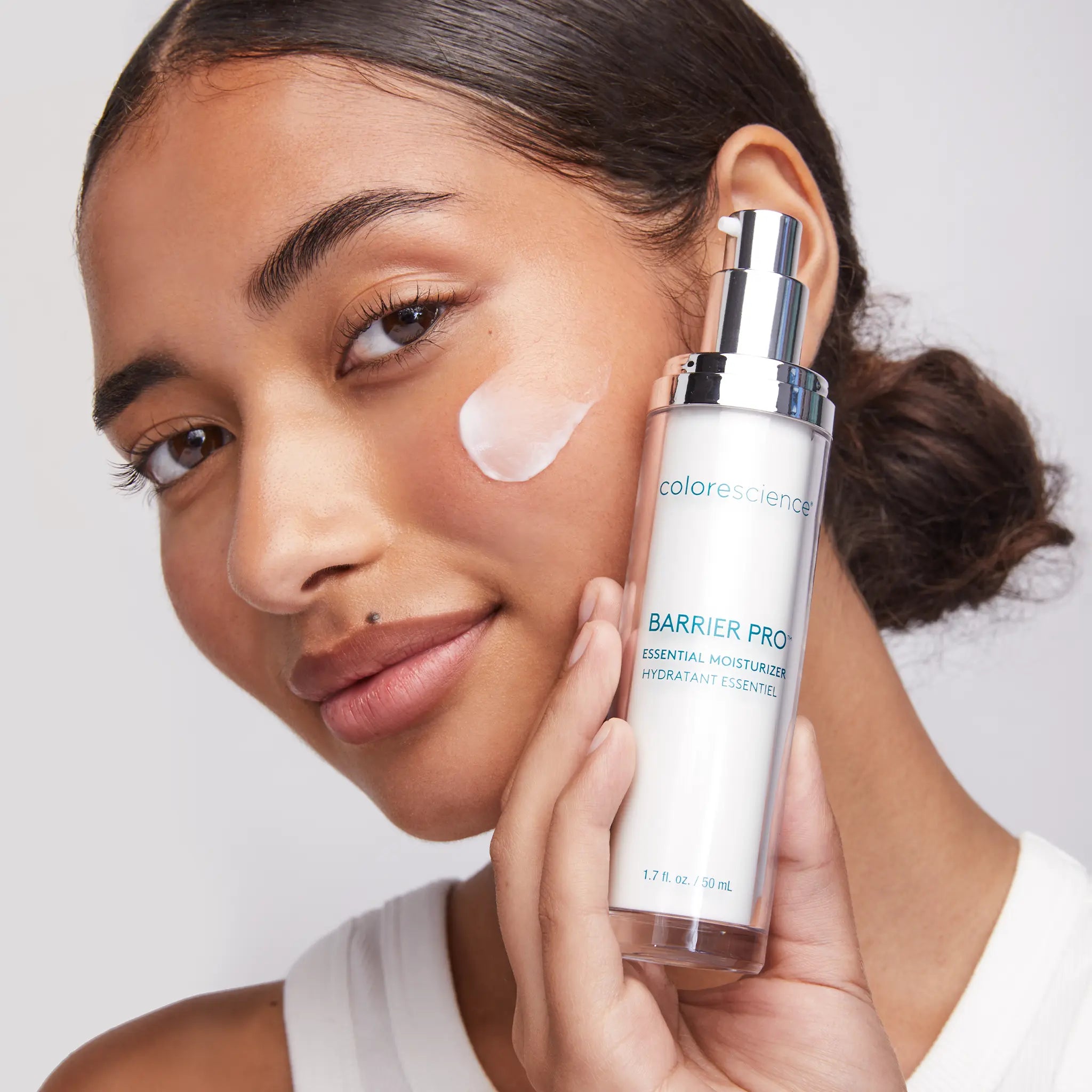 woman holding Barrier Pro™ Essential Moisturizer || all